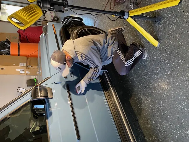 Professional technician applying protective coating to vehicle surface